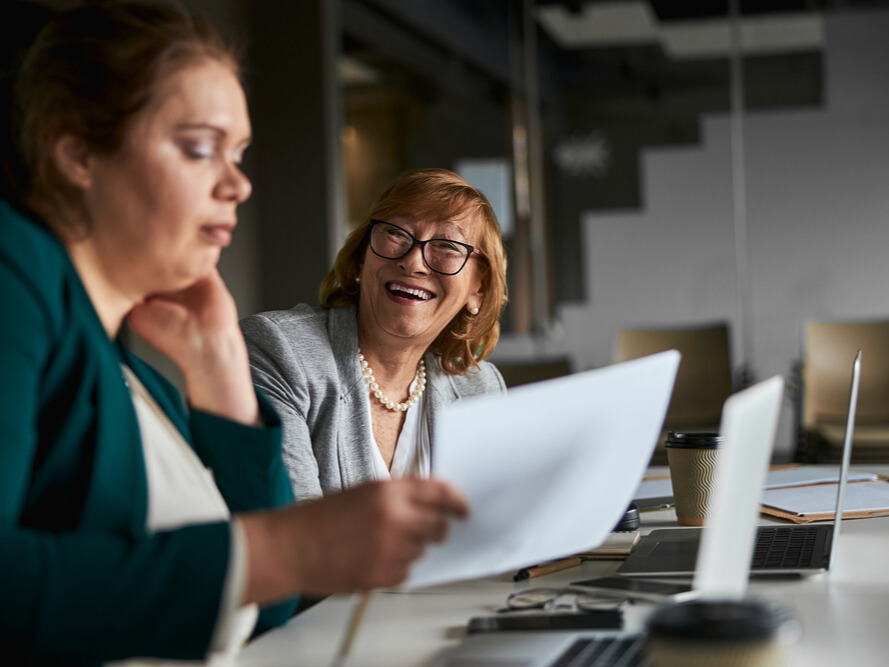Two colleagues reviewing documents together during an office meeting.